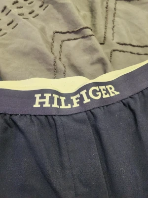 Marinblå kalsonger från Hilfiger - Snygga marinblå kalsonger från Hilfiger med bred resår i midjan och vit logga framtill. Klassisk passform och mjukt material som sitter skönt hela dagen. Perfekta för dig som gillar stilrena underkläder med en tydlig logga.