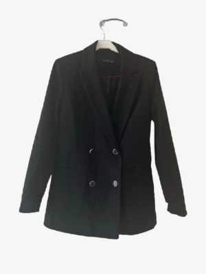 Svart dubbelknäppt kavaj reserved🌸 - Stilren svart kavaj från Vero Moda med dubbelknäppning och klassisk krage. Långärmad modell med två rader silverfärgade knappar framtill. Perfekt för en trendig och snygg look. Materialet är mjukt och följsamt.