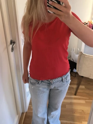  Korall t-shirt  -  Säljer en korall t-shirt med Volanger på armarna och Midjan. Passar om man ska vara lite uppklädd.