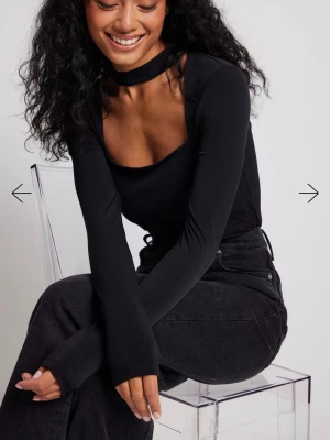 Svart långärmad topp med choker - Trendig svart långärmad topp från NA-KD med choker-detalj i halsen och figurnära passform. Endast använd en gång. 