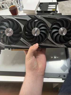 ASUS ROG Strix RX 6700 XT grafikkort - Snyggt och kraftfullt grafikkort från ASUS ROG Strix-serien, modell RX 6700 XT. Svart design med tre stora kylfläktar och robust kylare i metall och plast. Perfekt för gaming och tunga applikationer. Passar i de flesta moderna datorbyggen. 12GB vram