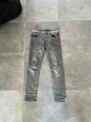 Replay slim fit jeans  - Hej! Säljer dessa gråa slim fit jeans från Replay i modellen Zikry. Jeansen har inga skador förutom ett hål (bild 5) som enkelt går att laga, annars är de i fint skick. Bara att hör av dig om du vill ha mer info!!
