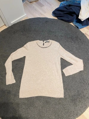 Långärmad ulltröja från Esprit st s. - Fin naturfärgad/beige tröja. Trolig ull. Lapp bortklippt. Men inte ren acetyl eller polyester i alla fall. Jag upplever den som ull. En pärla borta på ärmavslut. Kan lätt ersättas med två nya knappar . Rygg 62 cm och Ärminnerlängd 48 cm