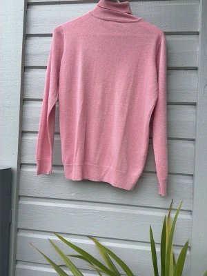 Rosa stickad tröja med glitter från Saint Tropez i strl XL - Säljer en rosa stickad tröja med diskret glittrande tråd i materialet. Tröjan har lång ärm och klassisk rak passform. Perfekt för dig som vill ha något enkelt men ändå lite extra.