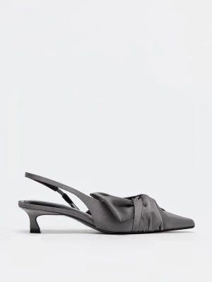 Gråa kittenheels med rosett och låg klack - Snygga grå pumps med spetsig tå och låg klack. Skorna har en elegant rosettdetalj framtill och öppen häl med smal rem. Tillverkade i ett tygmaterial som ger en matt finish och stilren look.