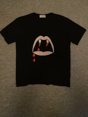 Saint Laurent Tshirt  - Säljer denna otroligt feta saint Laurent tahirten! Osäker om den är äkta därav priset! Storlek M men slimfit så passar även S! Tveka inte att skriva vid minsta fundering😁 sänker pris vid snabb affär
