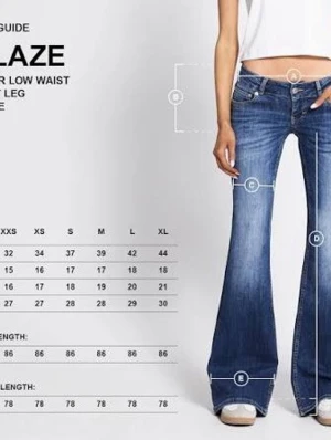 Blå bootcut jeans från Replay - Snygga blå bootcut jeans från lager 157 med låg midja och utsvängda ben. Jeansen har klassisk femficksdesign, slitningar och ljusare partier framtill för en cool look. Perfekta för dig som gillar retrostil och vill ha ett par jeans med attityd.