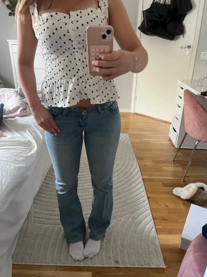 Ljusblå bootcut jeans med brodyr - Säljer ett par lågmidjade ljusblå bootcut jeans från Nelly med rosa detaljer. Jeansen är avklippta längst ner då dom var för långa vid köp. Passar mig som är 164 💕använda ett fåtal gånger 🥰Nypris 699 kr 