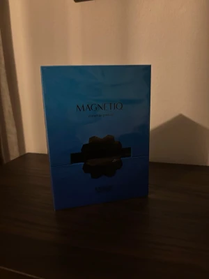 Magnetiq parfym från French Avenue - Magnetiq extrait de parfum från French Avenue i en snygg blå förpackning med svart dekor. Parfymen kommer i en rektangulär kartong och har en modern, stilren design. Perfekt för dig som gillar exklusiva dofter och vill ha något unikt i parfymhyllan.