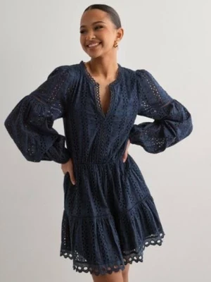 Mörkblå klänning med broderade detaljer - Supersnygg mörkblå kortklänning med broderade detaljer och v-ringning. Klänningen har långa puffärmar och volangkant nertill. Tillverkad i bomull, perfekt för dig som gillar en romantisk och trendig stil.