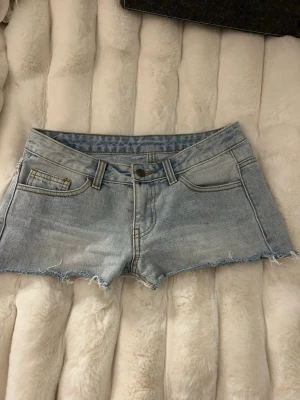 Ljusblå jeansshorts med fransig kant - Säljer ett par ljusblå lågmidjade jeansshorts med fransig kant. Köpt på brandy Melville.