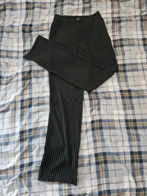 Svarta kostymbyxor med vita ränder - Snygga svarta kostymbyxor med vita ränder och raka ben från NA-KD i storlek S. Perfekta för en stilren look. 