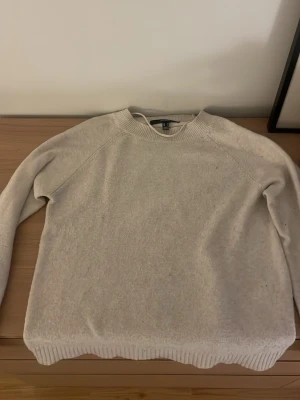 Beige stickad tröja från vero Moda - Mysig beige stickad tröja från vero Moda med rund halsringning och långa ärmar. Tröjan har ribbstickade muddar vid ärmslut och nederkant. Perfekt för lager-på-lager och enkel att matcha med olika outfits.
