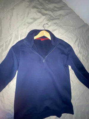 Marinblå fleece-tröja med half zip - Mysig marinblå fleece-tröja från Ryvita med hög krage och half zip-dragkedja. Perfekt för kyliga dagar och enkel att matcha med andra plagg. Tröjan har lång ärm och en klassisk, stilren design.