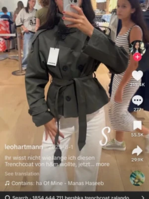 Olivgrön kort trenchcoat från Bershka - Snygg olivgrön trenchcoat från Bershka med dubbelknäppning, axelklaffar och bälte i midjan. Jackan har hög krage och är tillverkad i ett slitstarkt bomullstyg. Perfekt för dig som vill ha en trendig och stilren look. Aldrig använd ENDAST handtvättad en gång då tanken va att använda kappan. Storlek xs passa mig som bruka ha xs-s