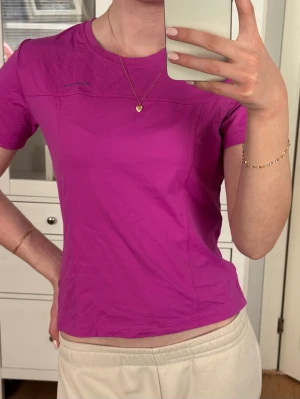 Rosa kortärmad träningströja  - Rosa tränings-tshirt med rund hals och korta ärmar. Tillverkad i ett stretchigt funktionsmaterial som andas och sitter skönt på kroppen. Perfekt för gymmet eller löprundan. Diskret logga på bröstet.