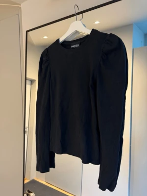 Svart långärmad topp  - En svart långärmad topp från Pieces med puffade axlar och rund halsringning. 