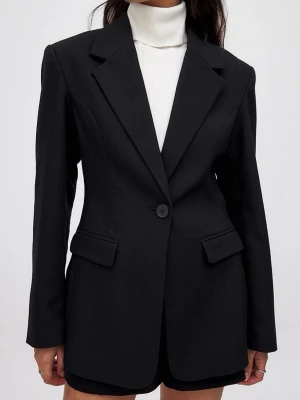 Svart oversized kavaj med breda slag - Stilren svart oversized kavaj med breda slag och en knapp framtill. Kavajen har två fickor med lock och markerade axlar för en trendig siluett. Perfekt att styla lager på lager. Endast använd 1 gång!