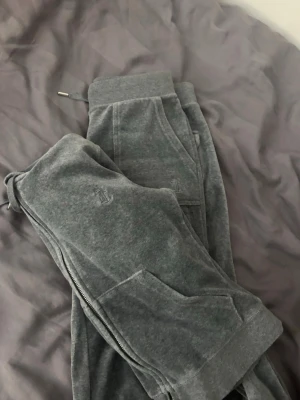 Grå velour mjukisset Juicy Couture - Grå mjukisbyxor och kofta i velour från Juicy Couture. Bra kvalite inget fel på de:)