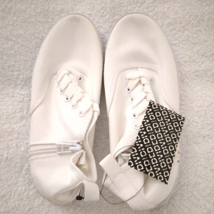 HELT NYA & OANVÄNDA höga sneakers från Divided / H&M, vit / vita, 36. - Helt nya, oanvända och felfria höga vita sneakers från H&M Divided. Tags/prislapp sitter kvar. Skorna har snörning fram och en dragkedja på varje sida. Smidiga/lätta att ta på och av. Snygga och perfekta för våren/sommaren. Skickas inplastade I originalförpackning. Storlek: 36. Material: tyg, troligen canvastyg. Modellen visar liknande skor.