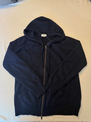 Mörkblå cashmere zip up hoodie  - Snygg mörkblå hoodie från Davida i 100% cashmere. Dragkedja framtill, huva och långa ärmar. Perfekt för dig som vill ha en mjuk och lyxig hoodie med enkel design och skön passform.