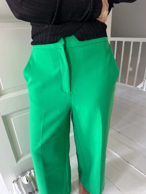 Gröna kostymbyxor från ZARA - Snygga gröna kostymbyxor från ZARA som är vida nertill . Perfekta för en trendig och färgstark look.