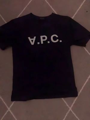 Mörk blå t-shirt från A.P.C. - Snygg mörk blå t-shirt från A.P.C. Storlek xs-s med klassisk vit logga framtill. Enkel och stilren design med normal passform och korta ärmar. Perfekt till jeans eller shorts för en clean look.