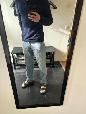Ljusblå raka jeans 32/34 - Säljer ett par ljusblå jeans med rak passform och klassisk femficksdesign. Jeansen har en avslappnad look och är tillverkade i denim. Perfekta för dig som gillar en enkel och tidlös stil. W32 L34
