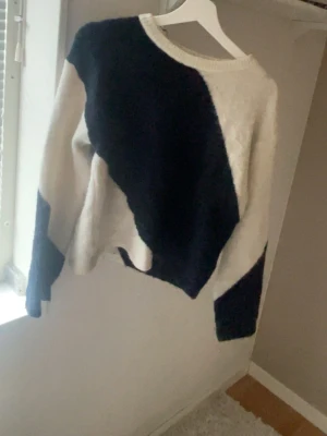 Svartvit stickad tröja Gina Tricot - Säljer en stickad tröja från Gina Tricot i storlek 158/164. Tröjan har ett coolt svartvitt mönster i breda diagonala block, rund halsringning och långa ärmar. Materialet är mjukt och mysigt, perfekt för kyligare dagar.