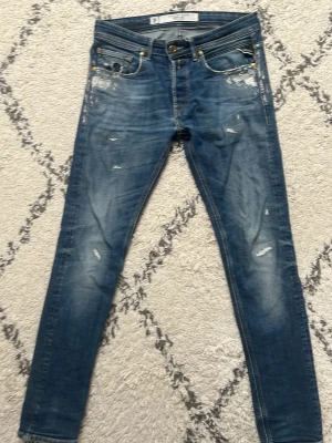 Blå slitna replay jeans - Säljer ett par blåa slitna jeans från replay