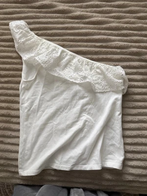 Vit oneshoulder topp med volang - Sitter som s och finns inte i butik .