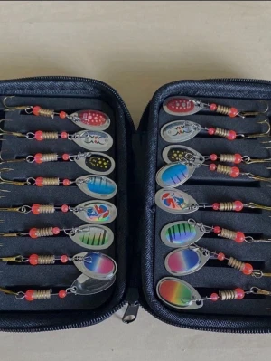 Fiskedrag spinnare set i fodral Hengjia - Säljer ett set med färgglada fiskedrag i metall, levereras i ett svart zipfodral. Drag i olika mönster och färger som rött, blått, grönt och regnbågsfärgat, med röda plastpärlor och trekrokar. Perfekt för dig som gillar fiske och vill ha variation i beten.