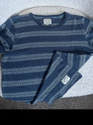 Suit Apparel mönstrad sweatshirt – Blå – Strl M - Säljer en snygg och skön långärmad tröja/sweatshirt från märket Suit Apparel. Tröjan har ett diskret och stilrent mönster i blå nyanser.  Storlek: M  Material: Mjuk och skön bomull  Skick: Fint och välvårdat skick.  Detaljer: Klassisk rund halsringning (crewneck) med muddar vid ärmsluten och i midjan. Ett perfekt och bekvämt vardagsplagg till jeans.