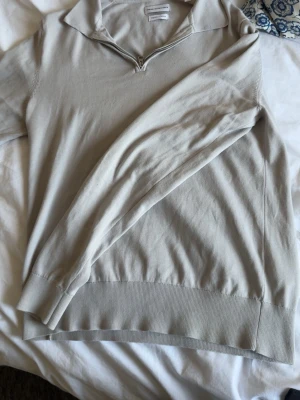 Beige halvzip-tröja These Glory Days - Snygg beige långärmad tröja från These Glory Days i mjuk superior cotton. Tröjan har halvzip-dragkedja vid kragen och ribbade muddar vid ärmslut och nederkant. Perfekt för en clean och stilren look.