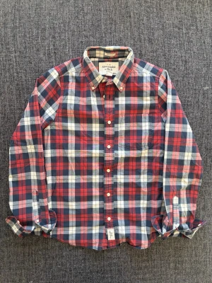 Abercrombie & fitch skjorta ~ 2000’s modell - Sjukt eftertraktad Abercrombie & Fitch skjorta ~ 2000’s modell som inte längre produceras | st M/true size | Rekomenderad längd mellan 174–184cm | Färg röd/blå/vit | OBS kan gå ner lite i pris vid snabb affär! 🏄