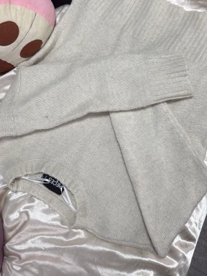 Beige stickad tröja från Pieces - Mysig beige stickad tröja från Pieces med rund halsringning och ribbade muddar vid ärmslut och nederkant. Tröjan har en enkel och stilren design som passar perfekt till lager på lager och är lätt att matcha med olika outfits.