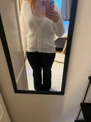 Vit cardigan  - Vit stickad v ringad tröja med knappar. 