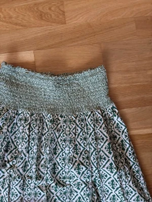 Zara lång kjol vit grön stl XS Ny - Jättefin lång tunn kjol från Zara i stl xs. Kjolen har en luftig passform och är perfekt för varma dagar. Materialet känns lätt och skönt mot huden.