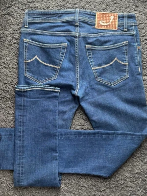 Jacob Cohën Jeans Type 622.C – Storlek 33  - Exklusiva Jacob Cohën-jeans med grym kvalitet! Handgjorda i Veneto, Italien. Oslagbara jeans, broderier och ikonisk patch. 🧵 Märke & Modell: Jacob Cohën - Type 622.C (J622 COMF) 📏 Storlek & Passform: Strl 33. Slim fit. 🧩 Material: 99% bomull / 1% elastan 📐 Mått: Midja: 41,5 cm Längd: 107,5 cm Benslut: 17 cm Lår från grenen: 25 cm ✅ Skick: 9/10 - Mycket fint skick. Kika på bilderna & gör egen analys! ✨ Detaljer: Broderier, citat & lyxknappar. 💰 Nypris: Ca 4500kr ‼️Skickas mycket snabbt‼️ 