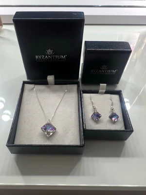 Smyckesset halsband och örhängen! - Säljer ett set med halsband och örhängen. Original förpackningarna kommer med. Jag köpte dessa på nossebro marknad, och det jag gick på var att dom var one of a kind, det vill säga är detta ända paret. Dom är i perfekt skick då jag inte har på mig silver och dom har använts 3-4 gånger sen jag köpte dom! 