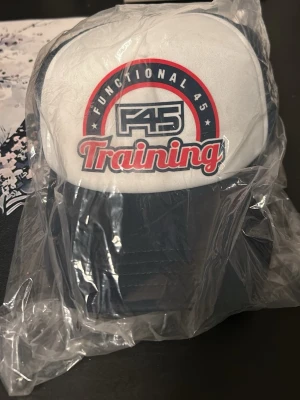 F45 Training keps vit och marinblå - Säljer dessa skit snygga kepsar du inte hittar någon annan stans. De är helt oanvända och i plast. De bara skriva vid funderingar 