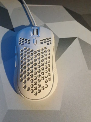 SR7 Gamingmus med honeycomb-design - Säljer en vit SR7 gamingmus med honeycomb-mönster för extra ventilation och lätt vikt. Musen har sladd och optisk sensor, perfekt för gaming och snabba rörelser. Tillverkad i plast och har en modern, ergonomisk form. Måste hämtas i Mönsterås 