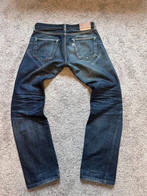 Tenryo TPD005 selvedge bootcut jeans - Säljer ett par riktigt schyssta blå selvedge bootcut jeans med snygg wash men finns fortfarande mycket mer potential i dem. Klassisk fem ficksdesign med knappgylf. Modell:TPD005  Storlek: W30 L30.  Ytterbensmått: 99cm. Innerbensmått: 79cm. Midjemått: 40cm. Benöppning: 19cm.                                                  Hör bara av er om ni har några frågor eller funderingar!!