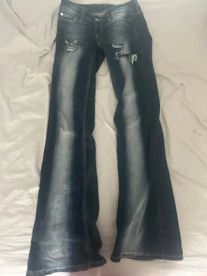 Blå bootcut jeans med slitningar - Snygga blå kvargiga jeans från weekday, gjort slitningarna själv. Säljer då dom inte kommer till användning💕