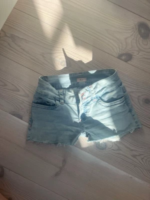 Ljusblå jeansshorts  - Säljer ett par ljusblå jeansshorts från Nelly. de är lågmidjade och har strecig midja så den passar bättre. säljer pga att inte passade dem. de står inte storlek men kommer inte ihåg om det var storlek 32 eller 34❣️❣️