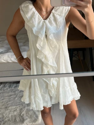 studentklänning zara - Supersöt vit kortklänning med volang framtill och lätt v-ringad hals. Klänningen passar perfekt till studenten eller liknande💕Storlek 13/14 år, 164cm❣️