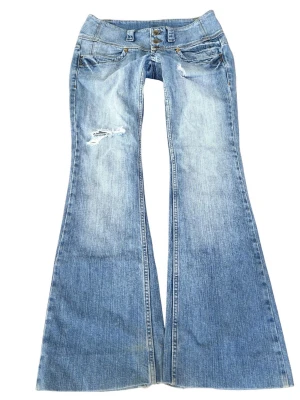 Vintage superlågmidjade bootcut jeans med slitningar - Såå sjukt snygga vintage superlågmidjade bootcut jeans med slitna detaljer, lite slitage vid skrevet men inga hål!! ❤️❤️ Innebenslängd: 80 cm Midjemått rakt över: 39 cm