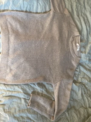 Beige stickad tröja från H&M - En enkel och stilren beige stickad tröja från H&M. Tröjan har rund halsringning och ribbade muddar vid ärmslut och nederkant. Perfekt för lager-på-lager och passar till många olika outfits. Och den är jävligt grisch