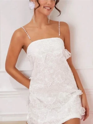 Studentklänning - Supersöt vit studentklänning med tunna pärlband och blommig spets. Klänningen har rak urringning och är ärmlös, perfekt för sommarens alla tillfällen. Snygg och feminin look med fina detaljer och lätt material, har aldrig använts 