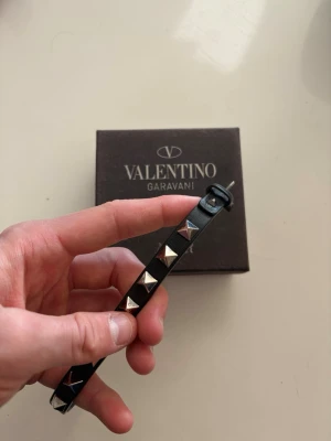 Valentino armband - Tjena! Säljer mitt svarta valentino armband i bra skick som inte används längre. Låda osv + 1 extra nit följer med! Nypris 3000, säljer det för 1000✌🏼